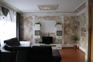 ein Wohnzimmer mit einem Sofa und einem TV in der Unterkunft The Lakehouse Villa Neusiedl am See Wienerstraße 8 in Neusiedl am See