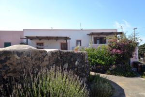 una casa con una pared de piedra delante de ella en Dammusi Eleonora, en Kamma