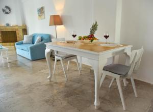 a table with a bowl of fruit and two glasses of wine at NanSea Apartment in Loutra Oraias Elenis 