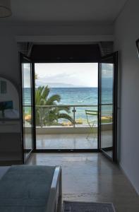 a bedroom with a view of the ocean at NanSea Apartment in Loutra Oraias Elenis 