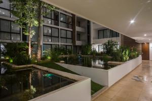 an external view of a building with a pond at Anah Suites in Playa del Carmen +61 photos