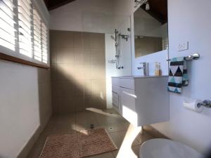 a bathroom with a shower and a sink and a toilet at Treetops Everglades Villa in Byron Bay
