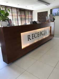 a reception desk with the name regrecia on it at Atrium Apartament in Sarbinowo