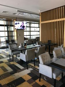 une salle de conférence avec des tables, des chaises et un écran dans l'établissement Atrium Apartament, à Sarbinowo