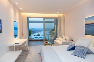 a bedroom with a bed and a view of the ocean at Lindos Mare, Seaside Hotel in Lindos