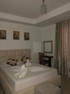 un dormitorio con una cama con dos animales de peluche en Hotel Soan en Sarandë