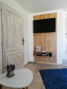 a living room with a flat screen tv on a wall at Apartman JulRich in Vrbov