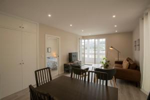 a dining room and living room with a table and chairs at Noray Apartamentos Viveiro in Viveiro