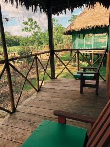 une véranda d'une cabane avec un banc et une table dans l'établissement Iguana Lodge Perú, à Iquitos