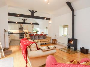 a living room with couches and a fireplace at Gwel y Rhos in Llanfairpwllgwyngyll
