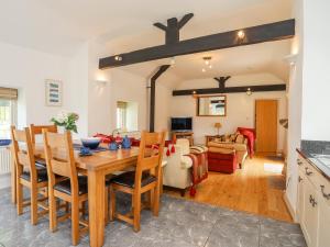 a kitchen and living room with a wooden table and chairs at Gwel y Rhos in Llanfairpwllgwyngyll