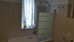 baño con ducha y bañera y ventana en G&G2 Appartamento con giardino, en Nonio 21 fotos más