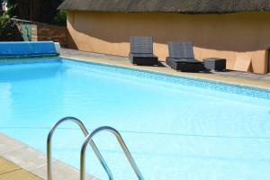 a swimming pool with two lounge chairs in it at The Retreat in Redlynch