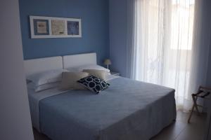 a blue bedroom with a bed with pillows on it at Casa Vacanze Lombardo in Santa Teresa di Riva