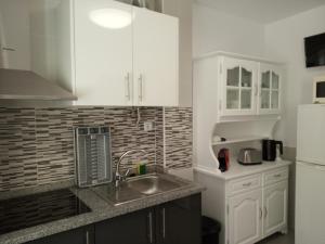 a kitchen with white cabinets and a sink at Casa do Sol - 70 m from the beach in Nazaré