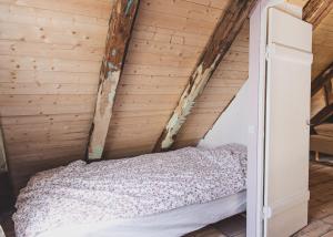 a bed in a room with a wooden wall at A pearl in the center of the center of Thorhavn in Tórshavn