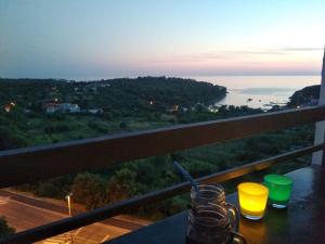 a table with two glasses and a view of the ocean at sky in Pula
