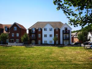 a group of houses in a park with a grass field at Cosy Apartment with Balcony in Herne Bay