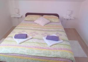 a bed with two pillows on top of it at Apartman Pazin in Klek