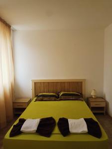 sypialnia z zielonym łóżkiem z 2 poduszkami w obiekcie Guest Apartments Salena w Słonecznym Brzegu