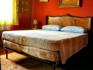 un letto in una camera da letto con parete arancione di BED & BREAKFAST da marco a Toscolano Maderno