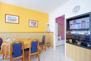 Un comedor con una mesa y un televisor de pantalla plana. en Apartments Mise, en Makarska