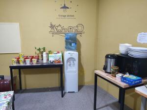 a kitchen with a small refrigerator and two tables at Inca Motel in Daejeon