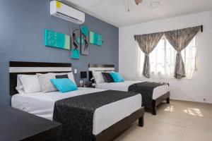 Dos camas en un dormitorio con paredes azules. en Santa Fe Studios And Suites, en Cancún