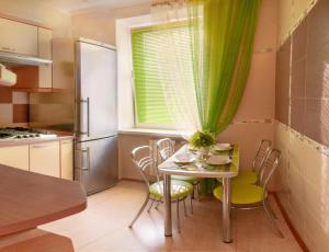 a kitchen with a table and chairs and a window at Poltava Green Apartments in Poltava