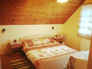 1 dormitorio con 1 cama con techo de madera en Guest House First Stop, en Rakovica