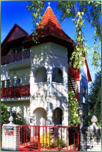 um edifício com uma torre com um telhado vermelho em White & Quiet Apartment House em Hévíz