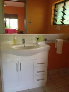a bathroom with a white sink and a mirror at Pink Flamingo Resort in Port Douglas