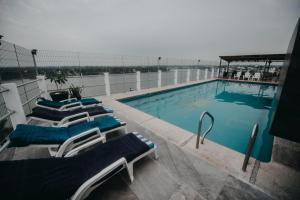 - une rangée de chaises longues à côté de la piscine dans l'établissement May Palace Hotel , à Tuxpan