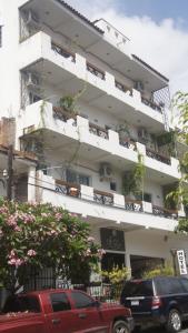 a white building with cars parked in front of it at Casa del Parque Vallarta in Puerto Vallarta