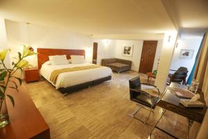 a hotel room with a bed and a desk and chair at Casa Comtesse in Mexico City