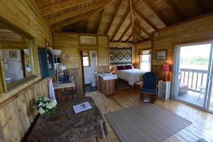 um quarto com uma cama num chalé de madeira em MareGold Centre - Juniper Cabin and Rose Cabin em Victoria Beach 