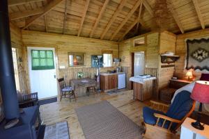 a cabin with a kitchen and a living room at MareGold Centre - Juniper Cabin and Rose Cabin in Victoria Beach 