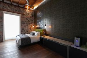Mumedi Design Hotel في مدينة ميكسيكو: غرفة نوم بسرير وجدار من الطوب