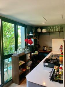 a kitchen with a counter and a counter top at KoHabitat Samui in Bophut 
