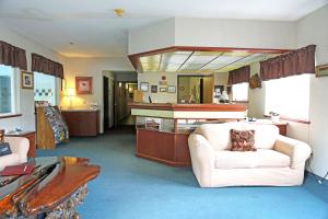 a living room with a white couch and a kitchen at Americas Best Value Inn & Suites-Forest Grove/Hillsboro in Forest Grove