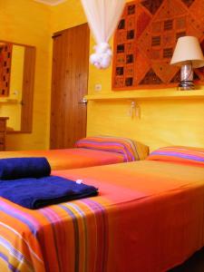3 camas en una habitación con paredes amarillas en Sol Y Brisa, en Sant Francesc Xavier