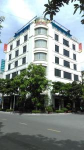 a large white building with trees in front of it at Golden Thai binh Hotel in Thái Bình