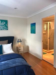 a bedroom with a bed and a walk in shower at Villa Alessandra Rooms & Restaurant in Mount Tamborine
