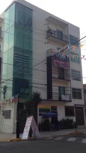 un edificio alto con un cartel delante en Departamento Frente al Aeropuerto 2 Rec, en Ciudad de México