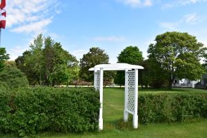 a white gazebo in the grass in a park at Lakeview Lodge and Cottages in Cavendish