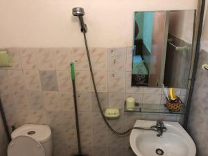 uma casa de banho com um chuveiro, um WC e um lavatório. em V A Motel em Haiphong