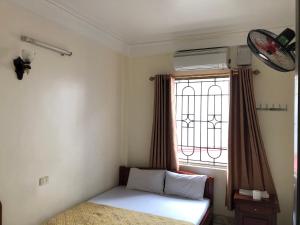 une petite chambre avec un lit et une fenêtre dans l'établissement V A Motel, à Hai Phong