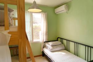 1 dormitorio con litera y ventana en Hello Project Guesthouse, en Jeju