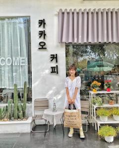 a woman holding a sign in front of a store at RAON Apartment & Hotel in Da Nang