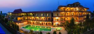 a large building with a pool in front of it at Hotel Royal Safari in Sauraha